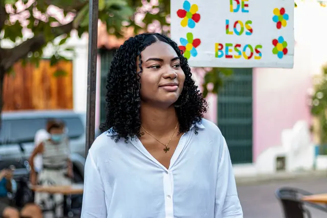 Modelo de camisa blanca bajo un letrero que dice de los besos