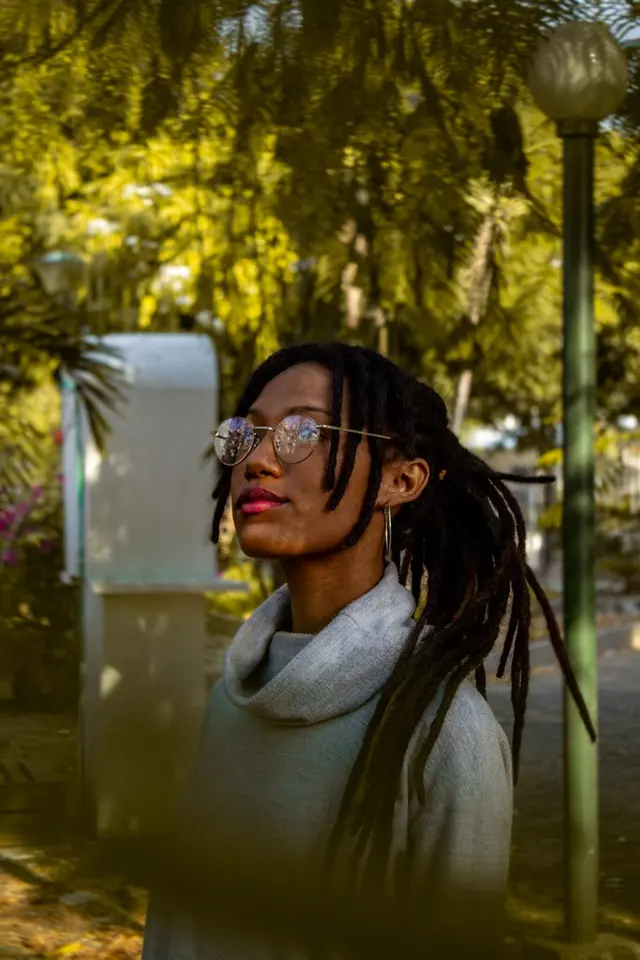 Modelo con gafas en un parque con luz dorada